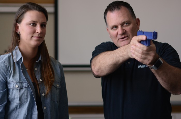 Kate Murphy watches as trainer Clark Aposhian demonstrates the proper use of a firearm for a teacher in a junior high classroom. Photo by: Jacob Byk